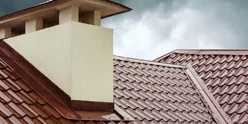 A brown roof with a white chimney on top of it.