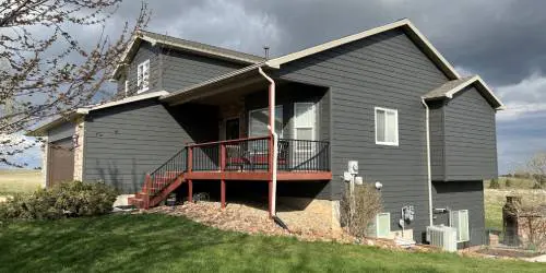 A house with a porch and stairs leading to the front door.